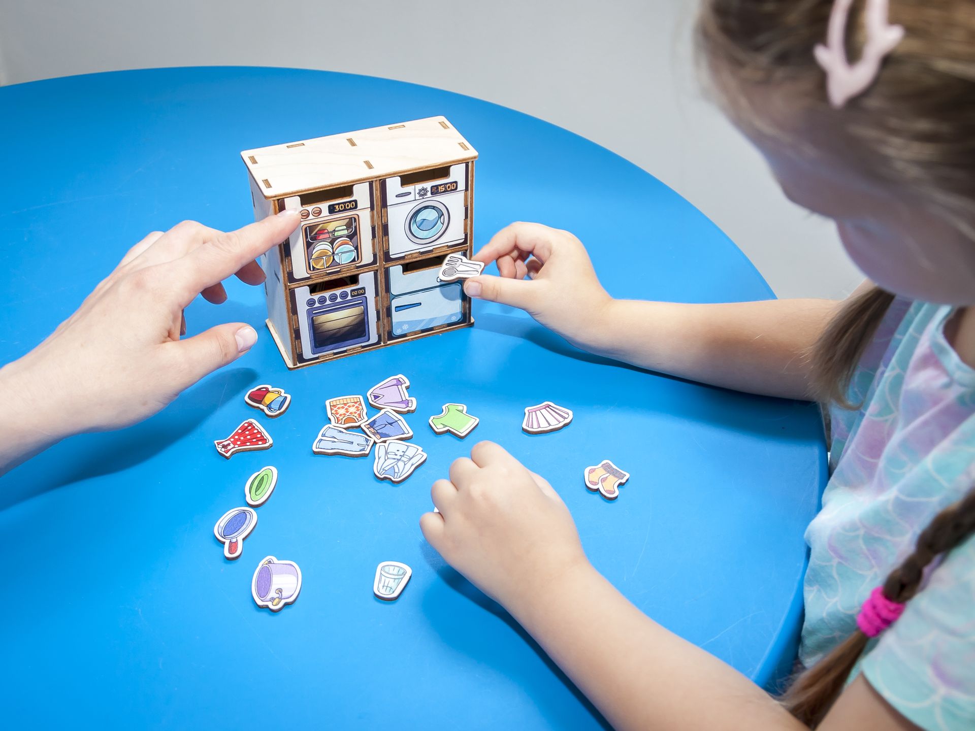 Игра — лучший путь к речи Игра с пиктограммами: девочка раскладывает карточки-предметы по ячейкам